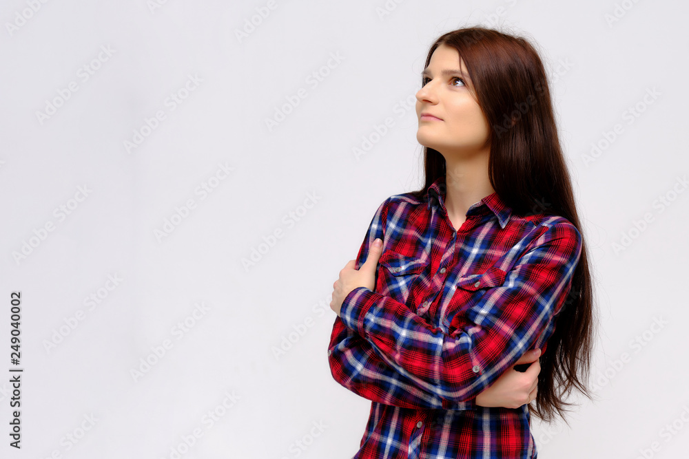 Concept studio portrait of a beautiful young beautiful brunette girl on a white background with different emotions in a multi-colored shirt. Concept studio portrait of a beautiful young beautiful brunette girl on a white background with different emotions in a multi-colored shirt.