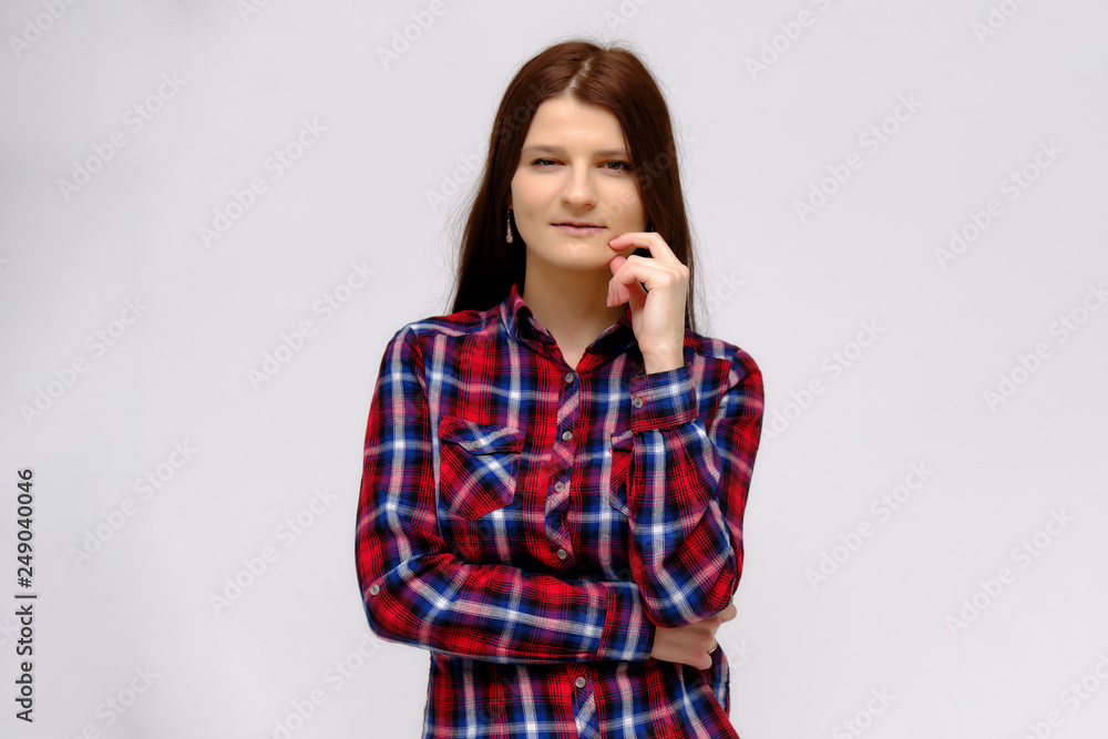 Concept studio portrait of a beautiful young beautiful brunette girl on a white background with different emotions in a multi-colored shirt. Concept studio portrait of a beautiful young beautiful brunette girl on a white background with different emotions in a multi-colored shirt.