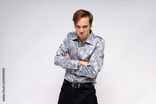Concept studio portrait of a handsome young man isolated on a white background with different emotions in a silver-colored shirt.