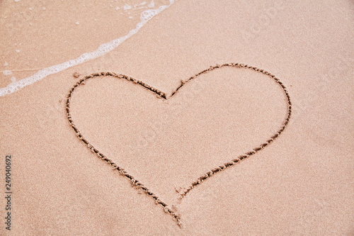 Drawing a heart on the sand. Sign of love