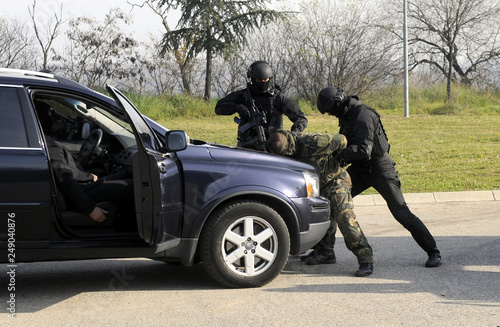 Bild auf Leinwand Special anti terrorist police unit arrest assaulter on a vehicle transporting vi