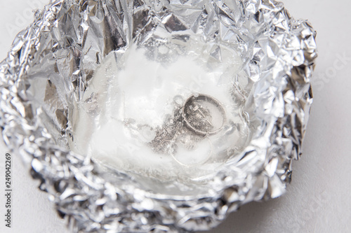 Фотография A solution of baking soda(Sodium bicarbonate) and warm water will remove the tarnish from silver when the silver is in contact with a piece of aluminium tin foil