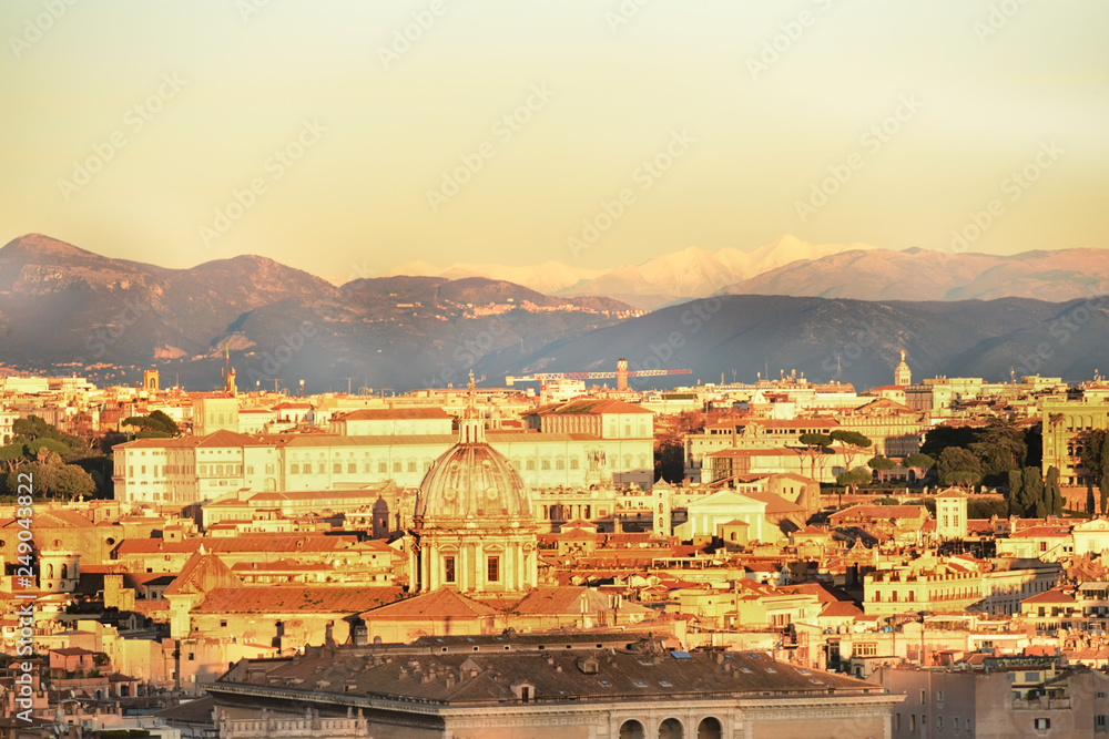 View of the city at sunset. On the horizon tops of mountains in the snow. Rome.