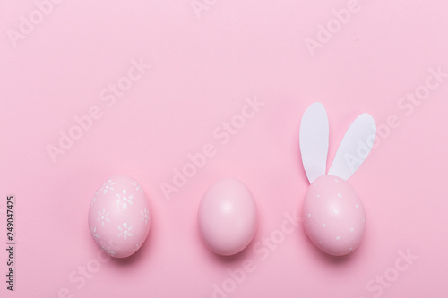 Pink easter eggs in nest on pastel color background with space. Concept