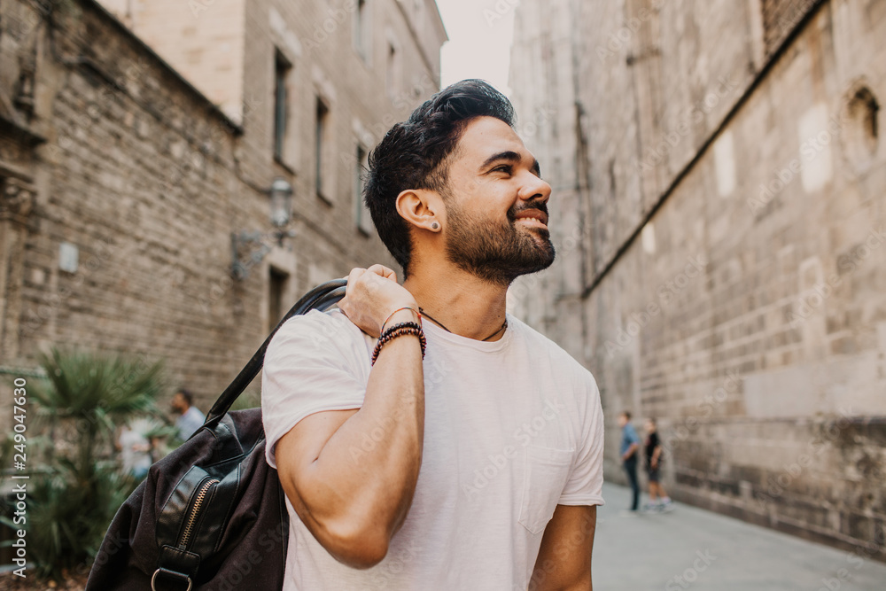 Obraz premium Traveler male discover a big europe city, travel and active lifestyle concept.Bearded Tourist Man with black leather bag enjoy beautiful city travel