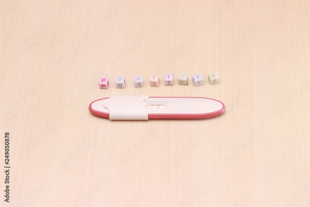 Pregnancy Test Pack Positive Result At Wooden Table And Text Positive From Colorful Alphabet Cube Bead Stock Photo Adobe Stock