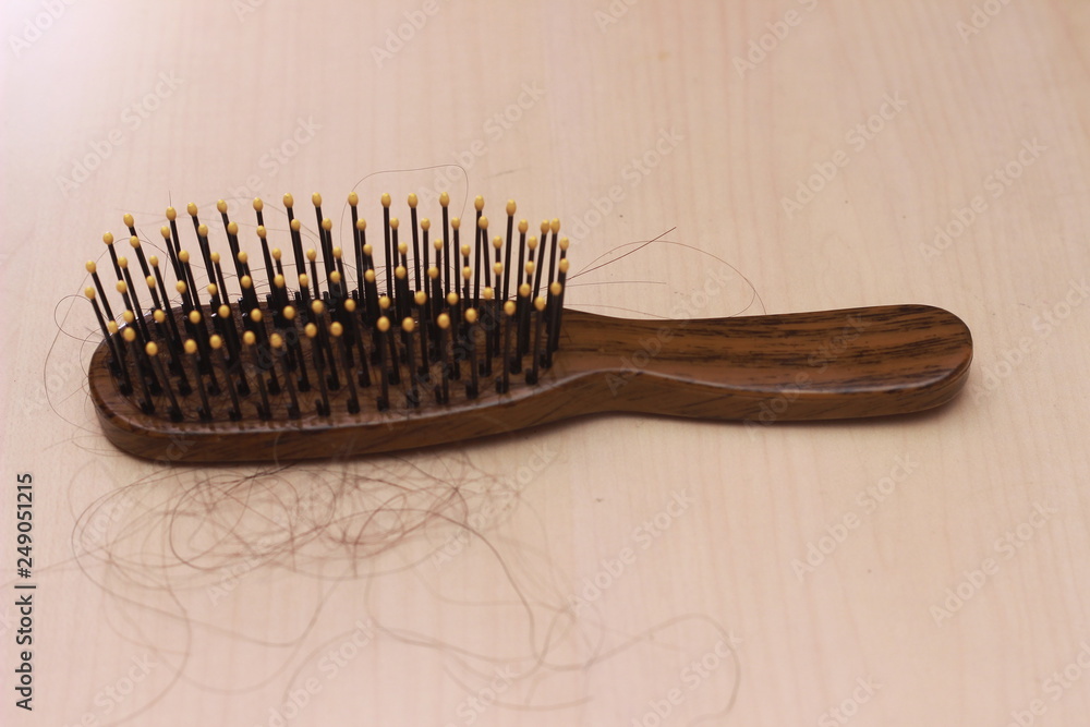 close up top view hair fall at white brown plastick comb at wooden table close up top view hair fall at white brown plastick comb at wooden table
