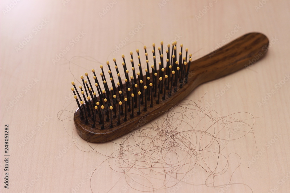 close up top view hair fall at white brown plastick comb at wooden table close up top view hair fall at white brown plastick comb at wooden table