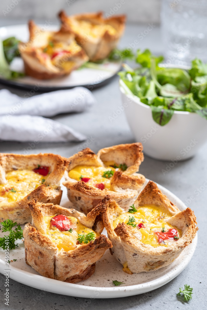 Egg muffins with peppers in a toast cup for breakfast brunch.