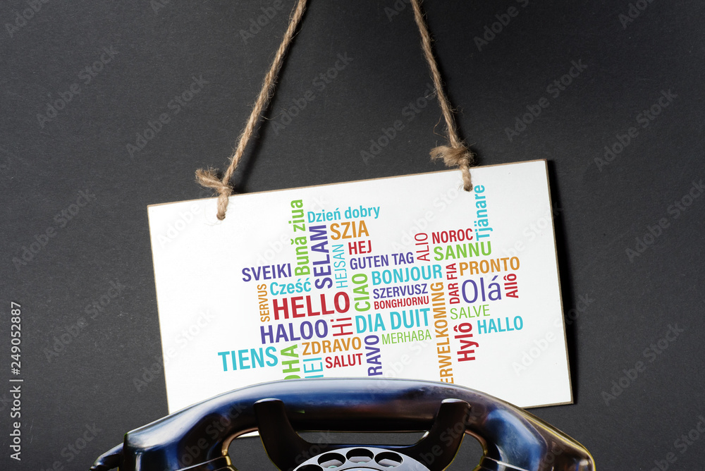 Ein altes Telefon und eine Tafel im dem Wort Hallo i verschiedenen Sprachen