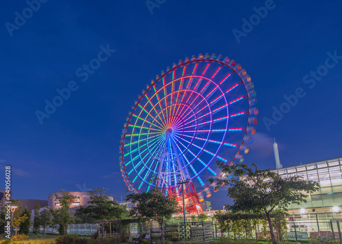 Odaiba illuminated Palette Town Ferris wheel named Daikanransha visible from the central urban area of Tokyo in the summer night sky. Passengers can see the Tokyo Tower.