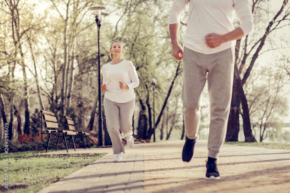 Sporty man jogging outdoors with his wife