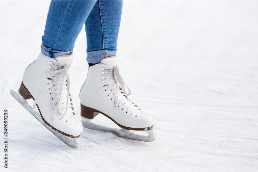 close up of legs in leather skates and copy space over white ice at rink close up of legs in leather skates and copy space over white ice at rink