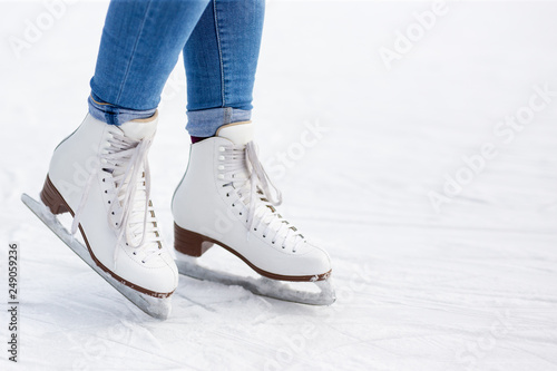 close up of legs in leather skates and copy space over white ice at rink