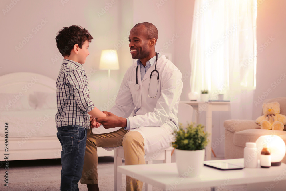 Obraz premium Smiling doctor calming child and preparing child for examination