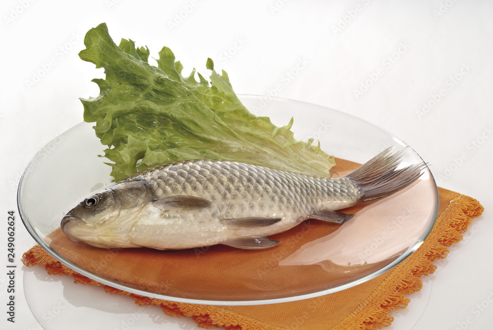pesce di fiume carassio in piatto con insalata.jpg altra inquadratura pesce di fiume carassio in piatto con insalata.jpg altra inquadratura