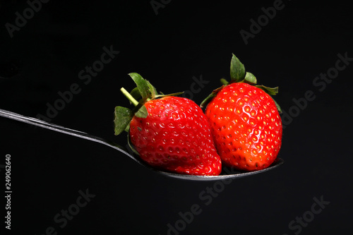 Fototapeta Naklejka Na Ścianę i Meble -  Strawberry on the spoon isolated over black background closeup view