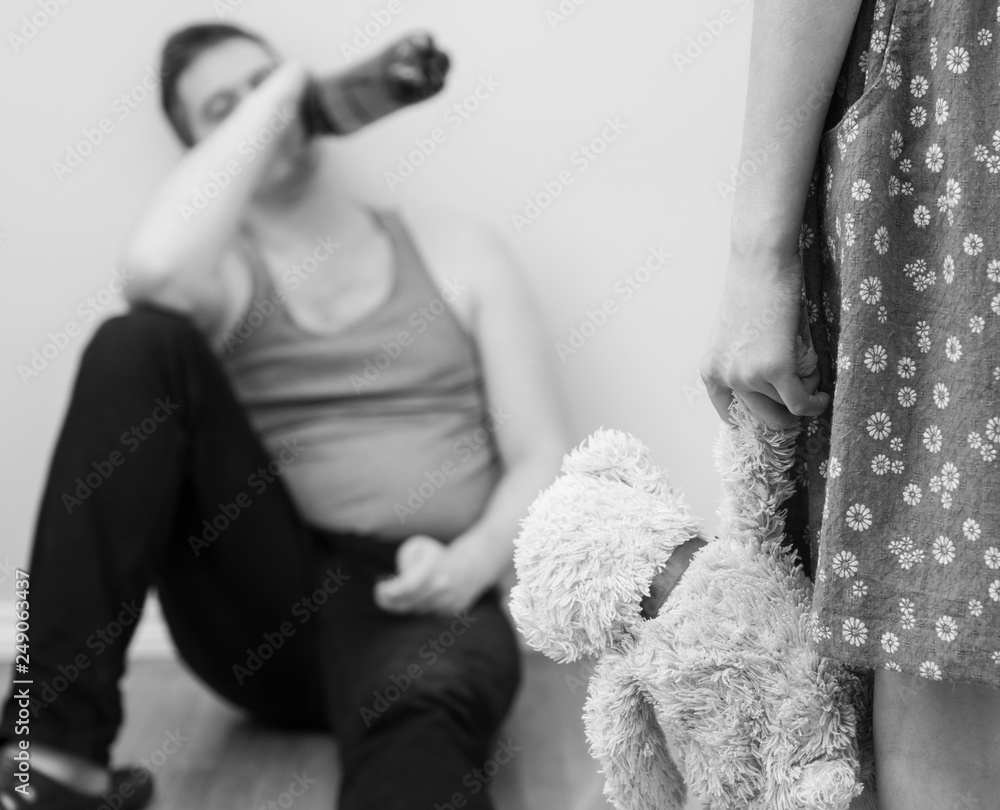 Little girl with toy standing in front of her drunk father. Little girl with toy standing in front of her drunk father.