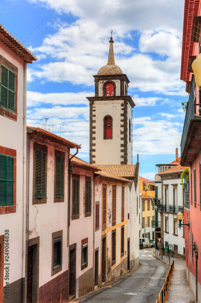 Beautiful vibrant cityscape in the streets of Funchal, Madeira, with the tower of the Parish of Sao Pedro on a summer day Beautiful vibrant cityscape in the streets of Funchal, Madeira, with the tower of the Parish of Sao Pedro on a summer day