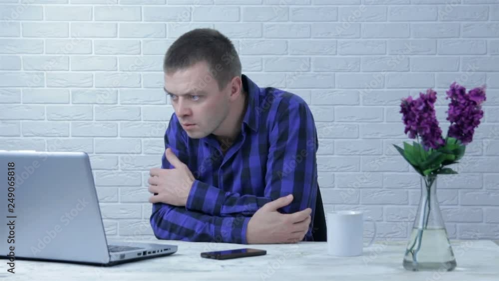 Surprised businessman with wide eyes behind a laptop computer with a ...