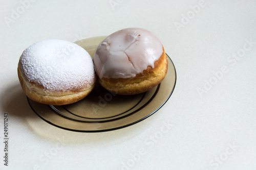 Donuts with icing and powdered sugar on a plate