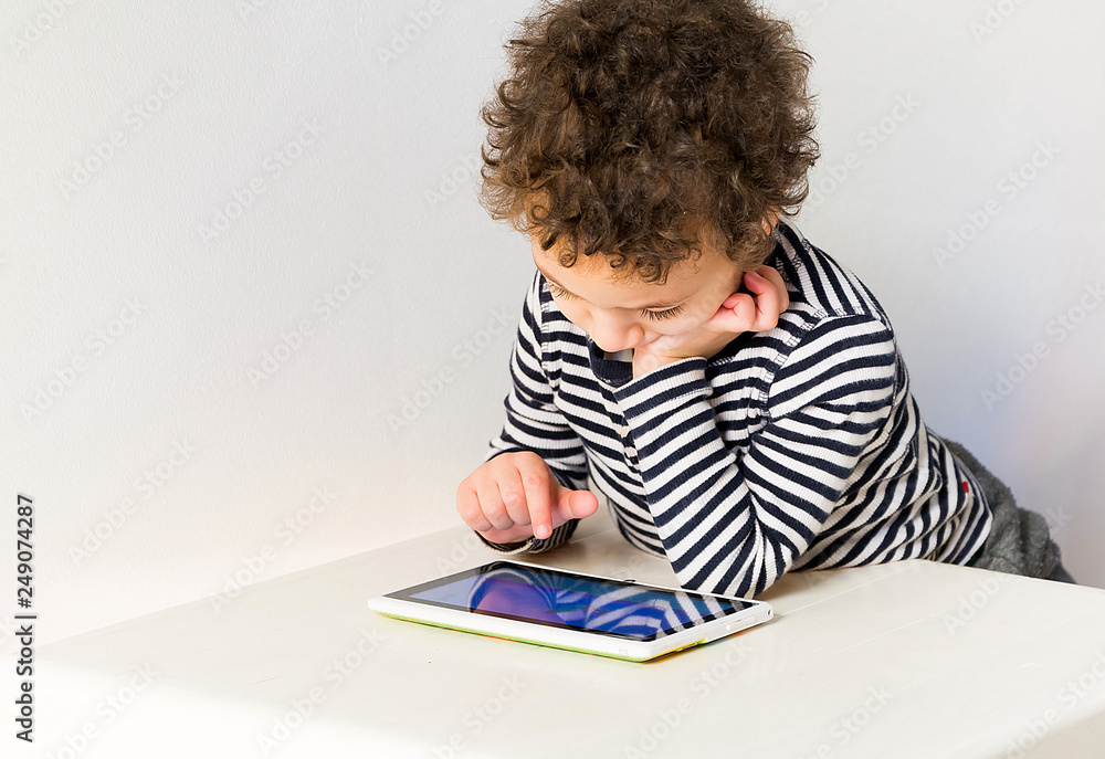 Naklejka premium child playing with digital tablet