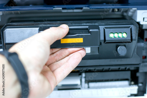 technician office worker fixing photocopy machine with replacement toner cartridge. refilling cartridge with toner for printing documents.