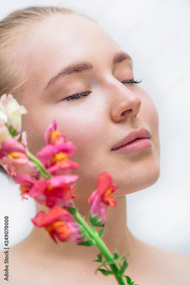 Beautiful girl's face with color flower near Beautiful girl's face with color flower near