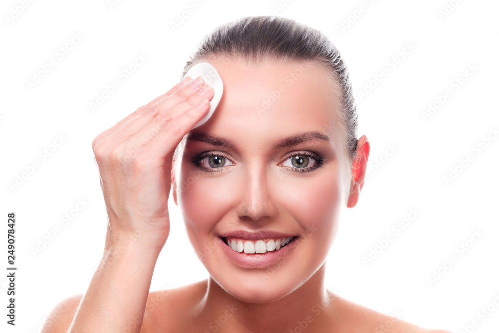 Pretty girl smiling to you. Skin care concept. Woman using a cotton pad, isolated on white background Pretty girl smiling to you. Skin care concept. Woman using a cotton pad, isolated on white background