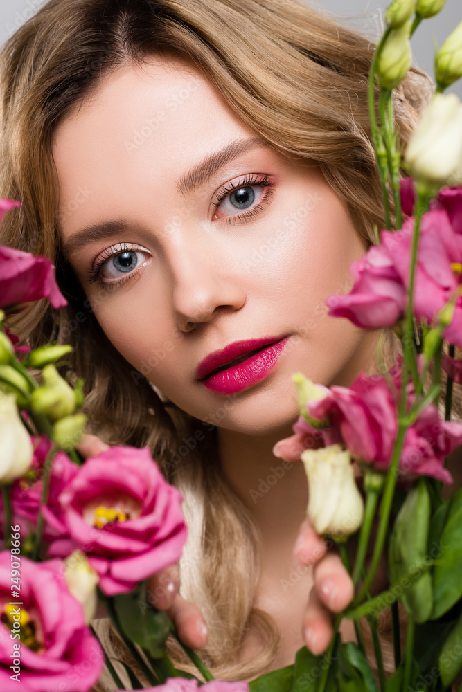 close up of spring young woman looking through Eustoma flowers close up of spring young woman looking through Eustoma flowers