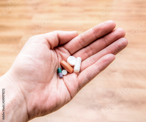 Tablets in hands, the person takes medicine, the choice of medical capsules