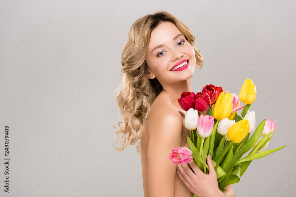 young smiling naked attractive spring woman holding bouquet of colorful tulips isolated on grey young smiling naked attractive spring woman holding bouquet of colorful tulips isolated on grey