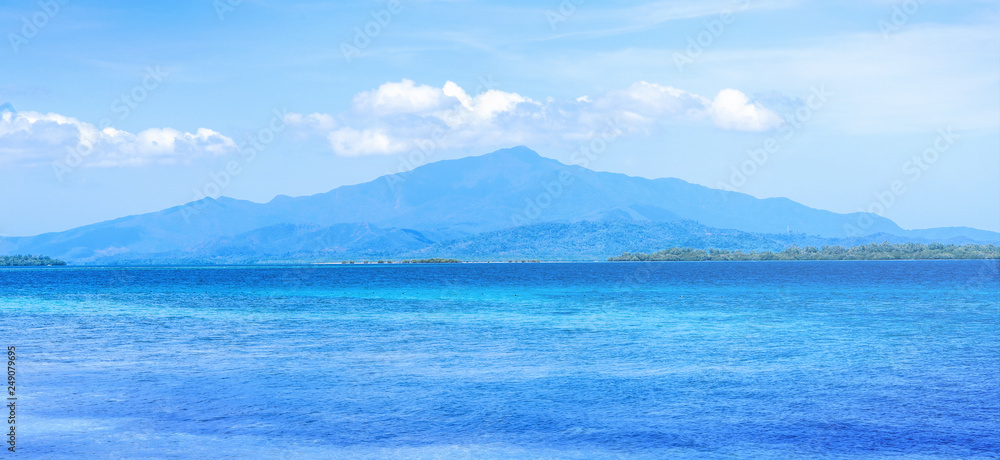 Beautiful ocean scene view isolated with light blue sky background, concept of vacation and sea travel, copy space