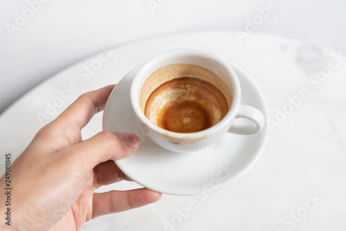 hand holding espresso coffee cup top view on table in cafe.