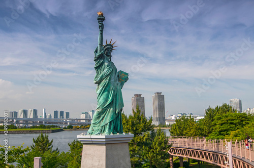 Replicas of the Statue of Liberty with cityscape background at Odaiba Park in Tokyo  Japan.