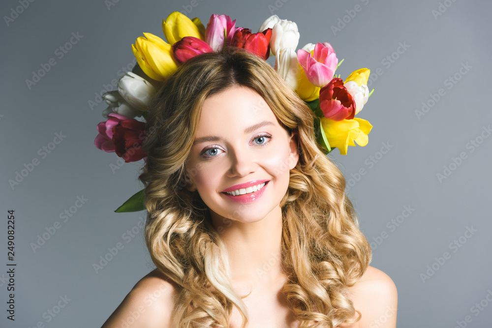 happy girl with wreath of flowers on hair isolated on grey