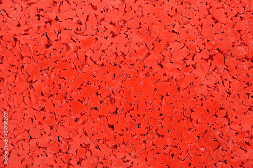 Red colored rubber floor background texture. Shock absorbent flooring for gyms, playgrounds, sports and running tracks photo