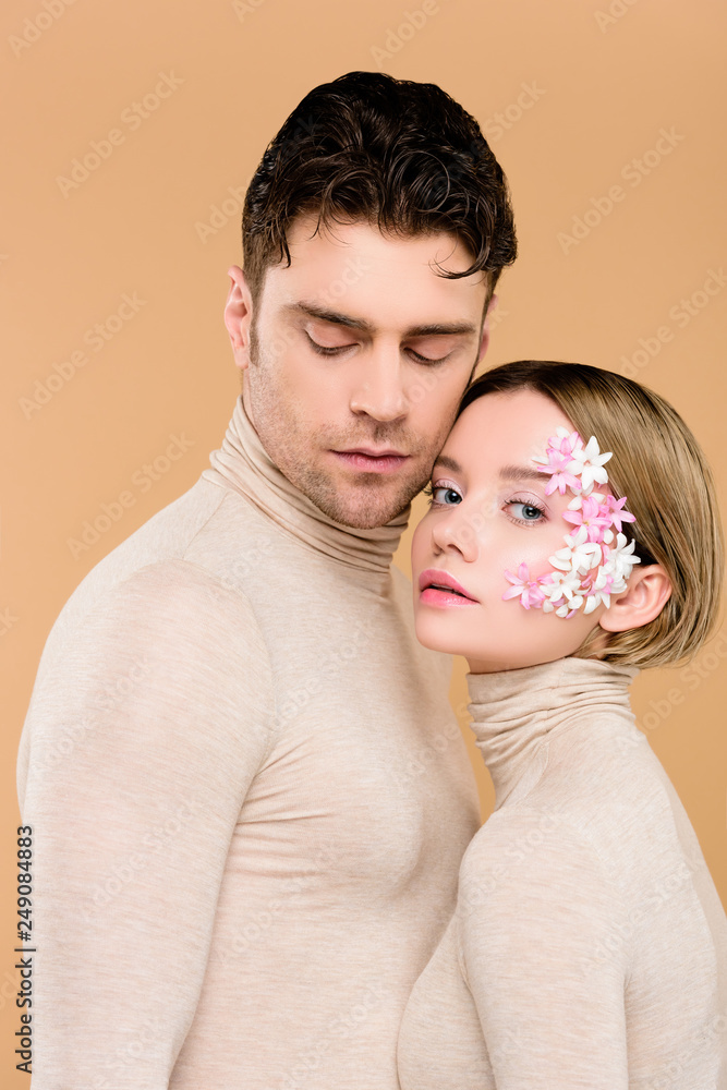 © LIGHTFIELD STUDIOS - tender woman with flowers on face standing with handsome man isolated on beige © LIGHTFIELD STUDIOS - tender woman with flowers on face standing with handsome man isolated on beige