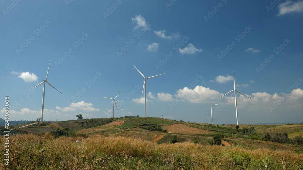 Windmill farm with blue sky and clouds