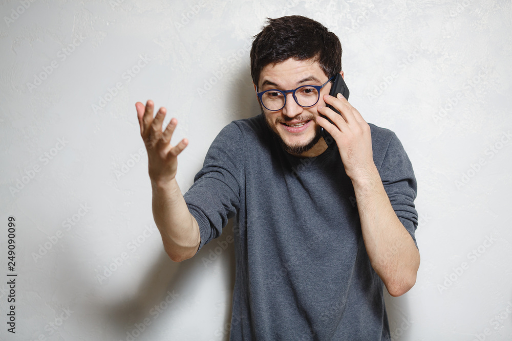 Portrait of young man solution to the problem on phone, over white textured background. Portrait of young man solution to the problem on phone, over white textured background.