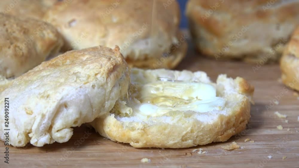 Pouring honey on a fresh baked biscuit, slow motion Pouring honey on a fresh baked biscuit, slow motion