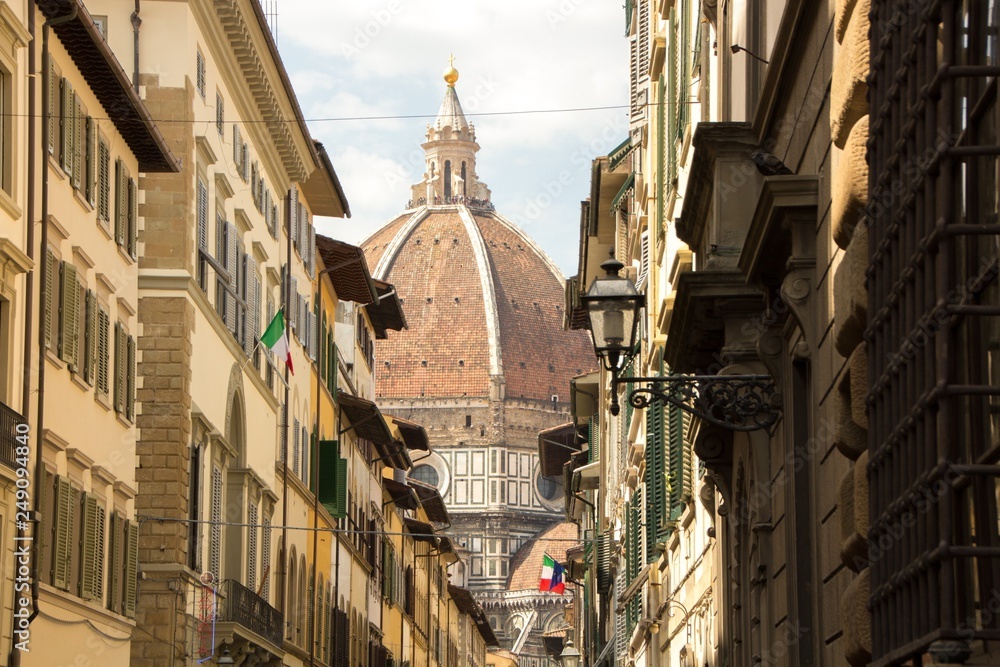 The dome of Cathedral of Santa Maria del Fiore, view from the narrow streets of Florence, Italy.