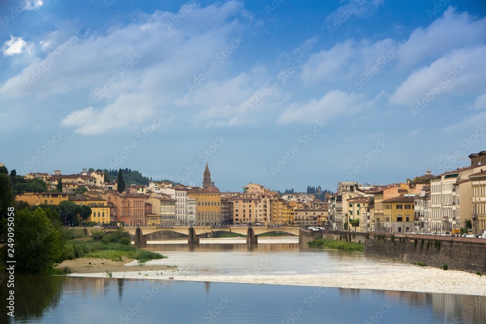 The Arno river and the cloudy Florence. Rainy weather with dark blue clouds hanging over the Italian city - Florence.