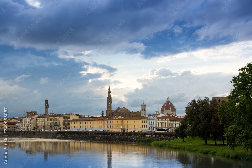 The Arno river and the cloudy Florence. View of the Cathedral of Santa Maria del Fiore, the Basilica of Santa Croce, Palazzo Vecchio and the Arno River on a rainy day. Florence, Italy.