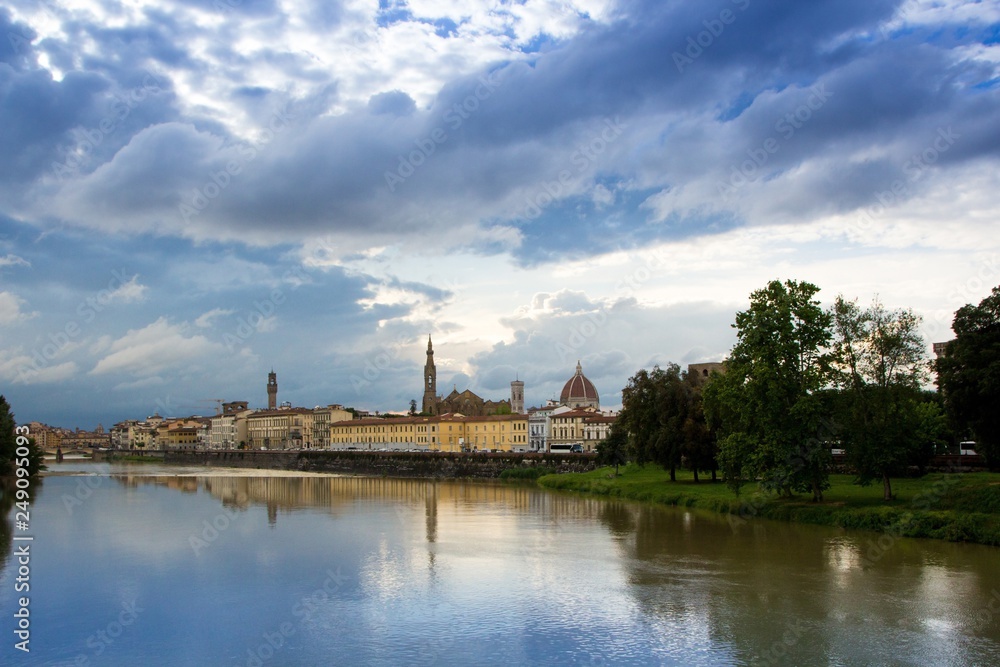 The Arno river and the cloudy Florence. View of the Cathedral of Santa Maria del Fiore, the Basilica of Santa Croce, Palazzo Vecchio and the Arno River on a rainy day. Florence, Italy.
