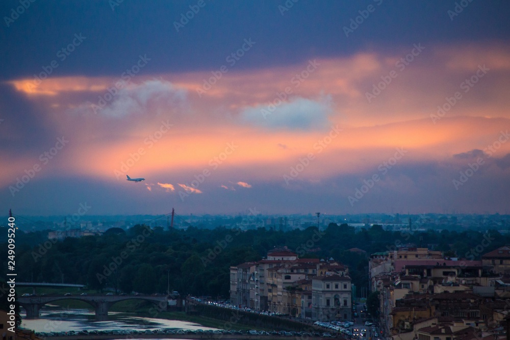 The plane flies over Florence in the evening. Beautiful dramatic sunset over Florence, Italy.
