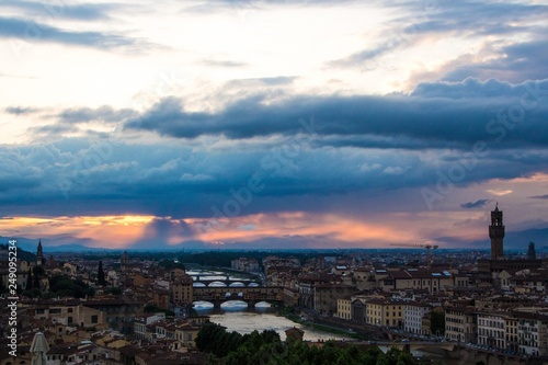 River Arno with bridge Ponte Vecchio and Palazzo Vecchio in the evening view from Piazzale Michelangelo. Dramatic sunset dark blue sky. Florence  Italy.