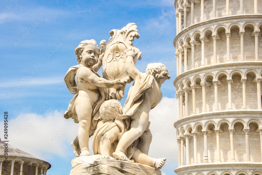Fontana dei Putti and Leaning Tower of Pisa (Torre pendente di Pisa) in Piazza dei Miracoli (Square of Miracles) in Pisa, Italy