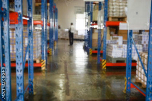 Blurry warehouse interior with shelves, boxes and document.