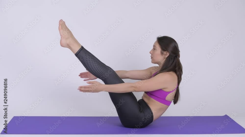 Young beautiful multi-ethnic woman doing Navasna yoga pose